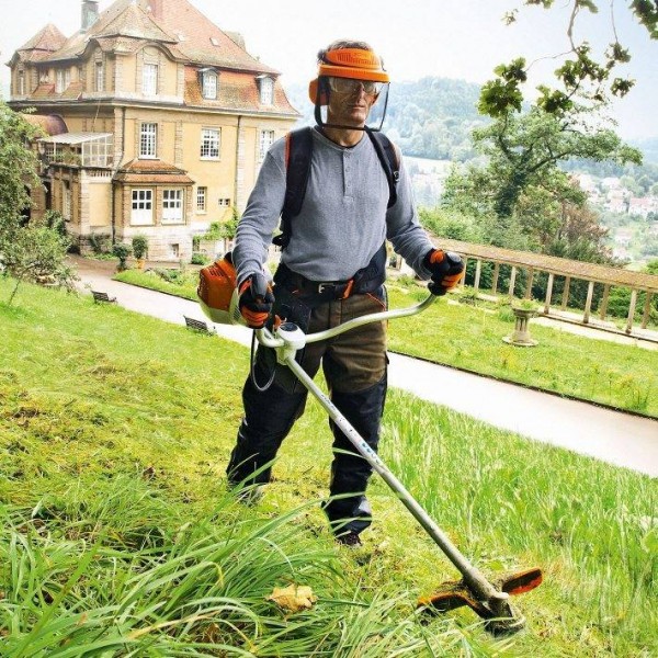 Un homme qui débroussaille un jardin 