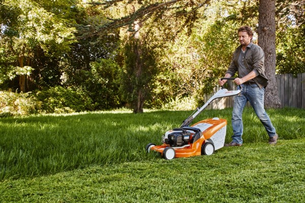 Un homme qui tond sa pelouse avec du STIHL