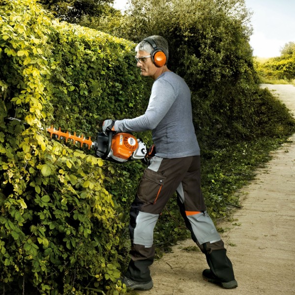 Un homme qui taille sa haie de jardin