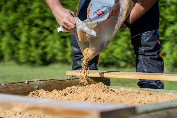 Dépose du sable dans la bac à sable